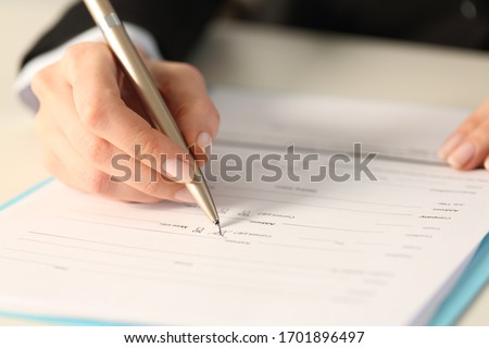 Close up of executive woman hand filling form checking yes checkbox sitting on a desk