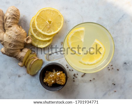 Top view of an immune boosting ginger and lemon tea with honey and black pepper on a marble plate 