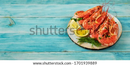 A wooden tray with bif argentinian prawns on vintage blue background
