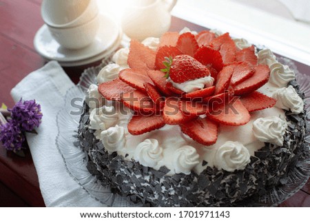Homemade cake with sponge cake, cream, milk cream, stuffed with strawberries on the plate