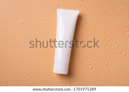 Flat lay flatlay top above overhead view photo of blank empty white tube for cream isolated over background with water drops Royalty-Free Stock Photo #1701975289