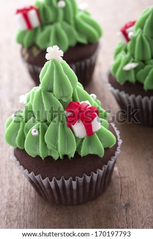 christmas tree cupcake decorating with gift box on the table.