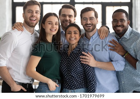 Group portrait of smiling diverse multiracial young businesspeople posing together in office, happy multiethnic millennial colleagues look at camera show unity and support at work, teamwork concept