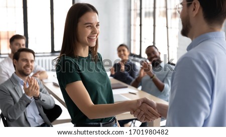 Businessman shake hand of excited Caucasian female employee greeting with achievement or success at office meeting, male boss or CEO handshake happy woman worker congratulate with work promotion Royalty-Free Stock Photo #1701980482