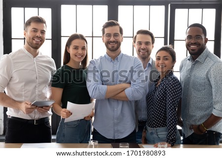 Group picture of happy diverse multiethnic young businesspeople posing together at workplace in office, portrait of smiling multiracial colleagues coworkers show unity and motivation in business