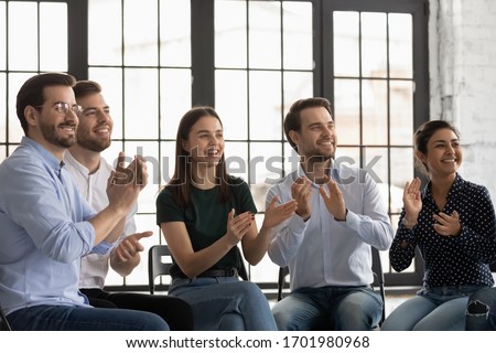 Overjoyed diverse young colleagues applaud celebrate victory or win at meeting, smiling multiracial businesspeople clap hands greeting congratulate business speaker or trainer, acknowledgment concept Royalty-Free Stock Photo #1701980968