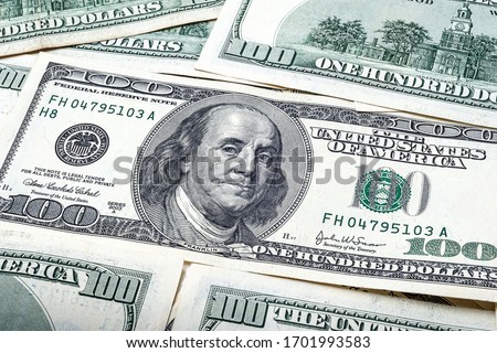One hundred dollars. Portrait of President Benjamin Franklin. US dollars background. Closeup of a lot of banknotes hundred dollar bills. American currency. Royalty-Free Stock Photo #1701993583