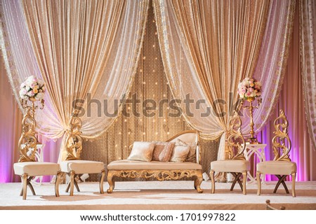 Romantic wedding decor with lit candles, elegant furniture, lush floral arrangements and inviting uplighting. Royalty-Free Stock Photo #1701997822