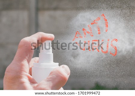 An adult sprays antiseptic from a can