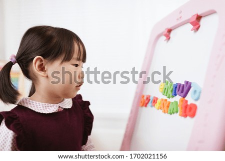 toddler girl learning letter blocks for homeschooling 