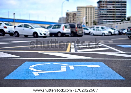 International Symbol of Access, a blue person in a wheelchair symbol painted on an allocated parking lot.