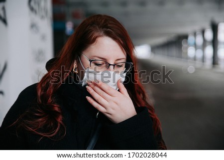 Woman feeling unwell and wearing face mask in city