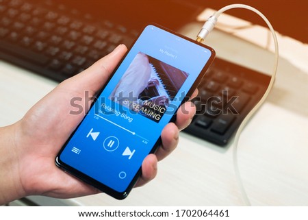 A man listening Music streaming application on smartphone, soft focus