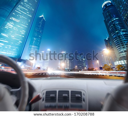 Driver's hands on a steering wheel of a car and night scene