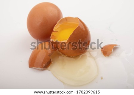 Broken chicken egg and chicken eggs scattered on a white background background. Close up.