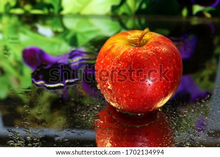 Apples: A single red apple shot in macro with a colourful background, and a reflection.