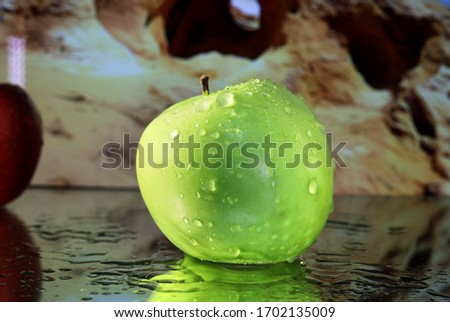 Apples: A single green apple looks so delicious all wet and reflecting light shot up close with sparkling reflections.
