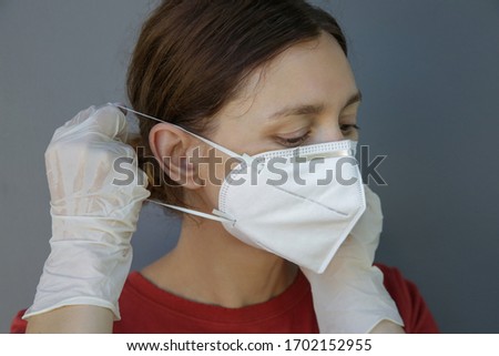 Close up portrait of young Caucasian woman wearing protective medical mask. COVID 19 novel Coronavirus outbreak or air pollution concept.	