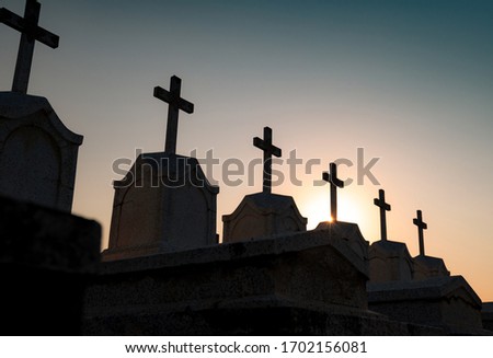Cemetery or graveyard in the night with dark sky. Headstone and cross tombstone cemetery. Rest in peace concept. Funeral concept. Sadness, lament, and death background. Spooky and scary burial ground.