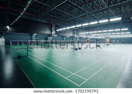 Big empty gymnasium with courts for playing tennis and badminton in health club Royalty-Free Stock Photo #1702198792
