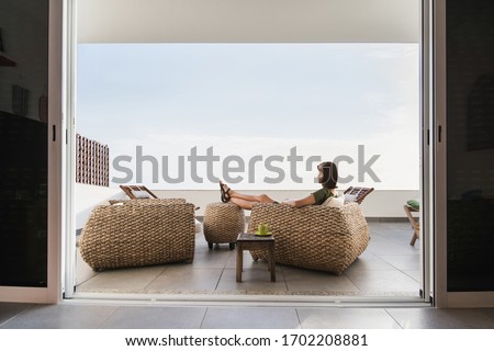 Young woman resting on terrace at home. Beautiful girl enjoying life. Vacations, relaxation, lockdown,resting, lifestyle and summer fun concept Royalty-Free Stock Photo #1702208881