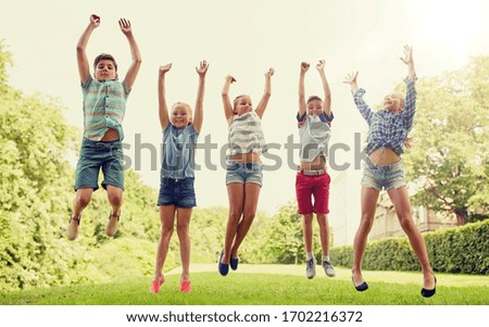 friendship, childhood, leisure and people concept - group of happy kids or friends jumping up and having fun in summer park