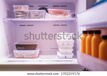 Frozen food in refrigerator. Meat, seafood, juice and ice on freezer shelves. Stocks of meal.