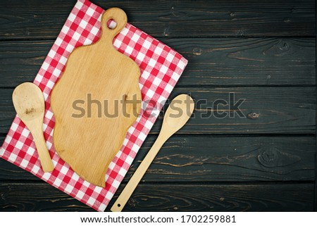 Red checkered tablecloth and wooden spoon for cooking and baking. Background with copy space. Horizontal.