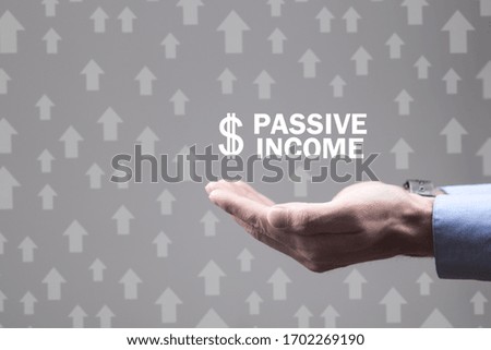 Male hands holding Passive income text with dollar symbol. Royalty-Free Stock Photo #1702269190