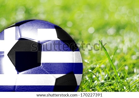 Soccer ball on grass with flag of Greece painted on it
