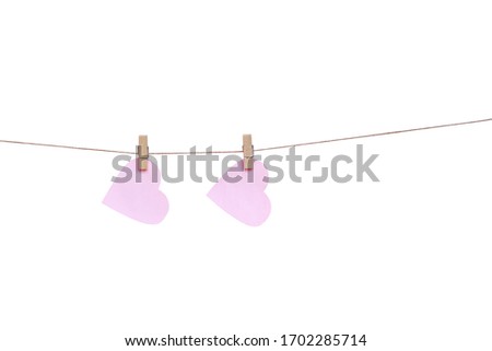 Wood clothes pins with two blank pink paper in heart shaped hanging on brown rope isolated on white background	, clipping path