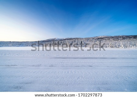  Icy road against snowcapped mountain Royalty-Free Stock Photo #1702297873
