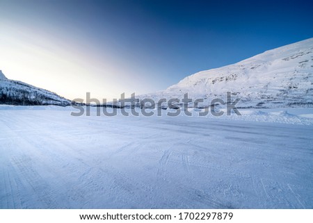  Icy road against snowcapped mountain Royalty-Free Stock Photo #1702297879