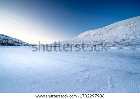  Icy road against snowcapped mountain Royalty-Free Stock Photo #1702297906