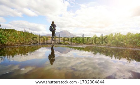 Reflection in water pond, Woman take a picture view Mountain landscape among cloudy in blue sky by medium format camera, Effect flare sunlight