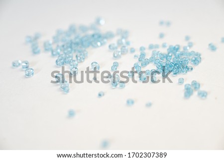 A bunch of blue seed beads of different size on white Royalty-Free Stock Photo #1702307389