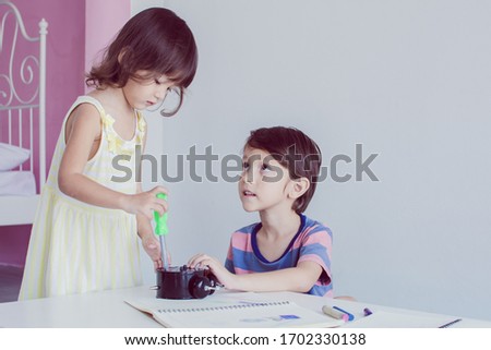 Caucasian little boy and girl playing toys together in a room at school
