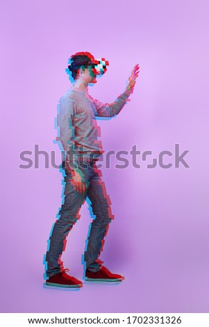 Man is using virtual reality headset. Image with glitch effect. Concept of virtual reality, simulation, gaming and future technology.