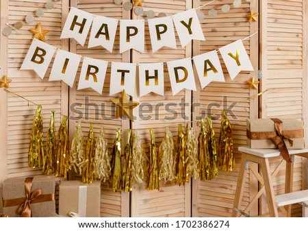 Birthday decorations with balloons, gifts, toys, garlands and candy for yearling, little baby party, celebration on a white wall background. Golden decor elements.
