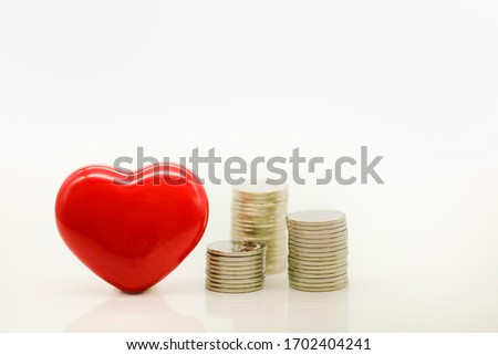 Money, Financial,Saving,Insurance concept, Closeup of stack of coins and ceramic red heart on white background and copy space for text.