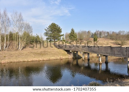 View of a small river with a bridge in spring. Channel of the Vileyka-Minsk water system for the transfer of water flow