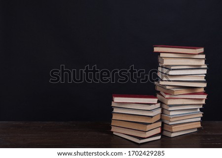 many stacks of educational books to teach in the library on a black background