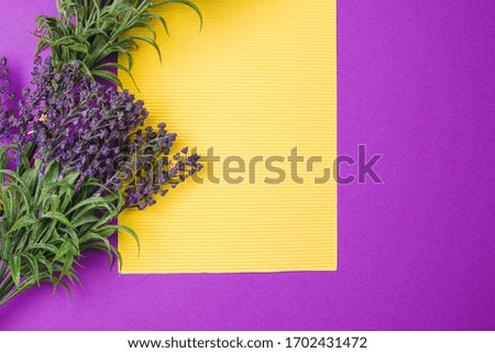 Blank yellow paper with lavender flowers on a purple background