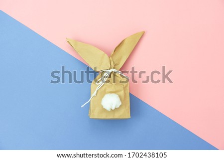 Top view shot of arrangement decoration Happy Easter holiday background concept.Flat lay minimalism paper bag same bunny or rabbit  for gift or present on modern pink paper at office desk.pastel tone.