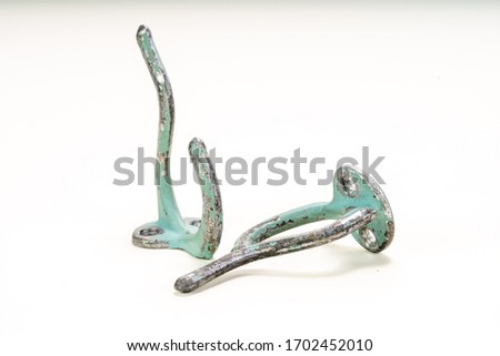 Worn painted wall hooks on a white background