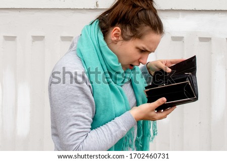 woman without money; portrait of poor  woman with empty wallet, poor people, poverty, bankruptcy, financial broke, unemployment, joblessness; no credit, no money concept Royalty-Free Stock Photo #1702460731