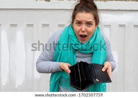woman without money; portrait of poor  woman with empty wallet, poor people, poverty, bankruptcy, financial broke, unemployment, joblessness; no credit, no money concept Royalty-Free Stock Photo #1702507759