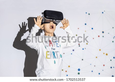 little boy using virtual reality device with save-the-earth t-shirt