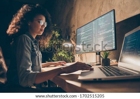 Profile side photo of concentrated skilled web expert afro american girl sit evening desk use computer netbook work java script html back-end algorithm in workstation workplace Royalty-Free Stock Photo #1702515205