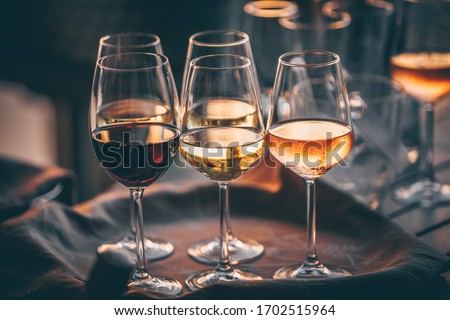 Rose wine glasses for a tasting with friends. Close up view Royalty-Free Stock Photo #1702515964